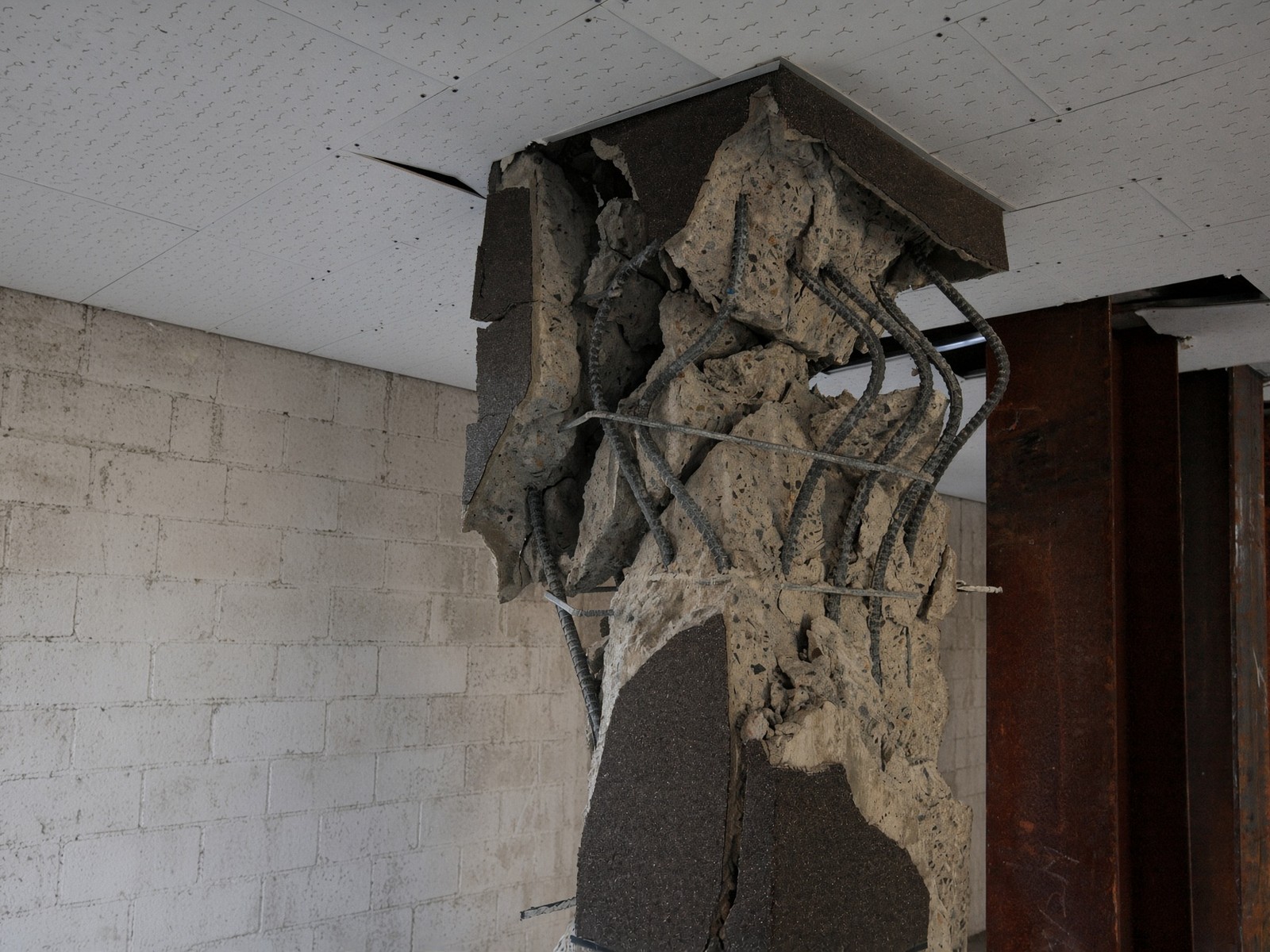 Failed reinforced-concrete column with buckled bars after seismic damage